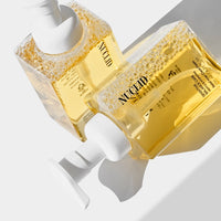 Two yellow bottles with white caps on a light gray background