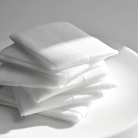 Stack of white napkins on a gray background
