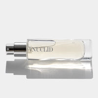 Perfume bottle with 'MENUCLID' branding on a reflective surface