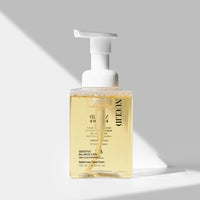 Foaming hand soap bottle with pump on a gray background