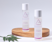 Two skincare bottles labeled 'Aaskin' on a wooden board with a white background.