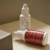 Two bottles of Aaskin solution on a beige surface with a neutral background